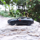Diecast electric car model in dark gray, side view, black wheels