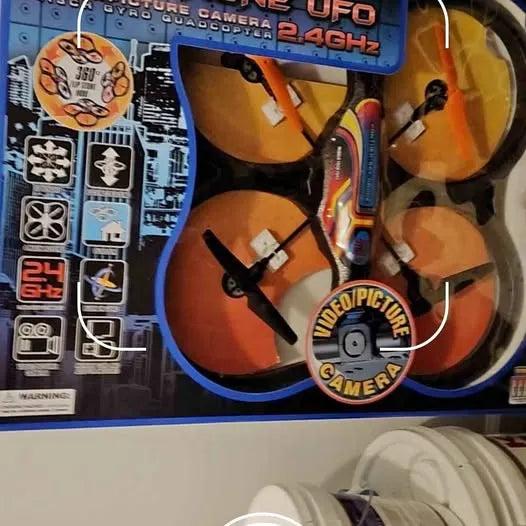Orange quadcopter toy drone with four propellers on retail box