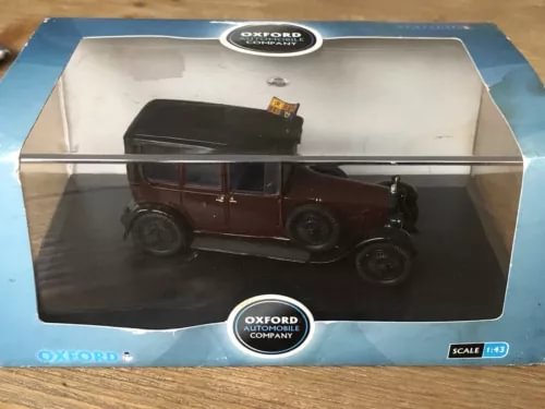 Diecast model car in display box, maroon vintage sedan with black wheels