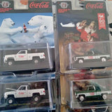 Coca-Cola M2 diecast pickup truck model in clear blister packaging, white cab with red logo.