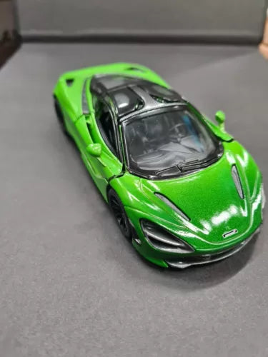 Green diecast sports car toy with black details, front 3/4 view, 1/36 scale.