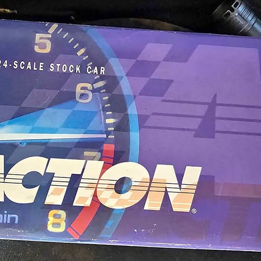 Diecast stock car box packaging with purple and blue checkered graphics