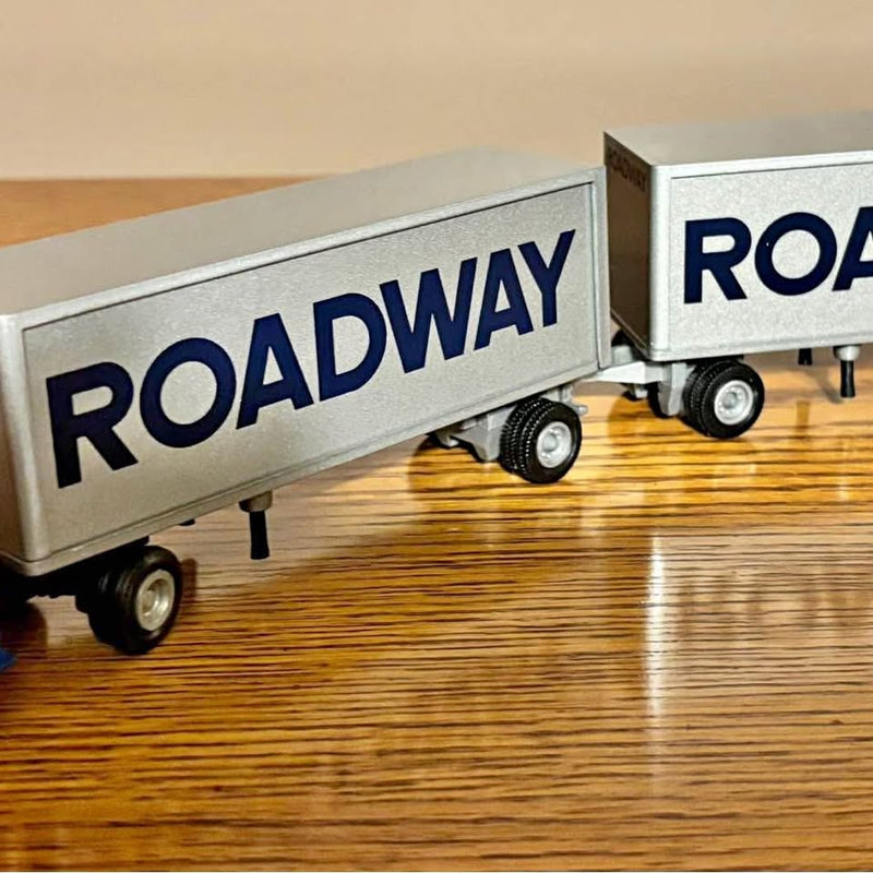 Diecast roadway semi truck with pup trailer; close-up of wheels and ROADWAY logo