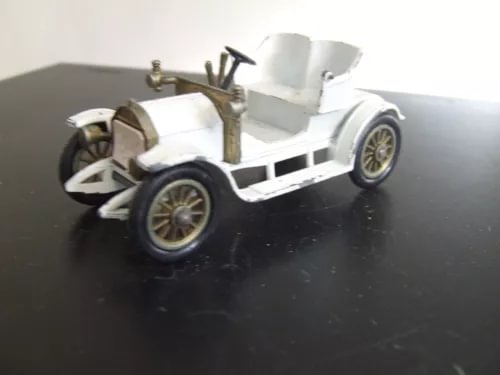 White vintage diecast toy car with open cockpit and gold-spoke wheels
