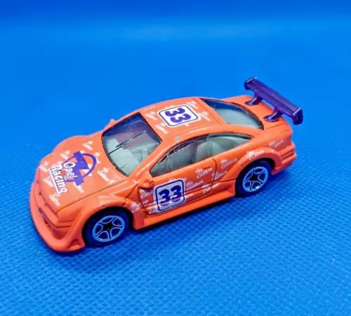 Orange 1/60 scale racing car diecast model with blue wheels, #33 on door