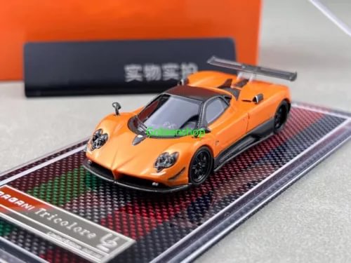 Orange racing sports diecast car model with clear windshield, on striped base