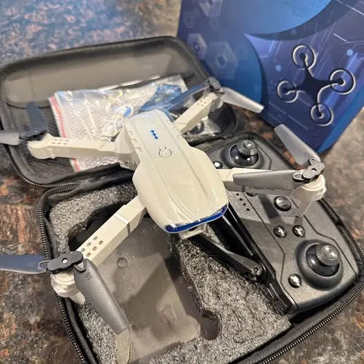 White toy drone with gray landing gear and blue-accent base