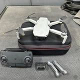White quadcopter drone with propellers, carrying case, and handheld controller