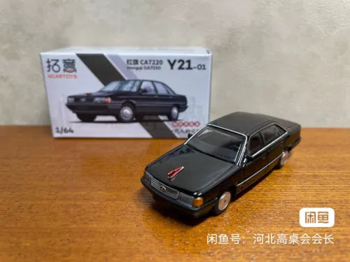 Black diecast model sedan car with red emblem