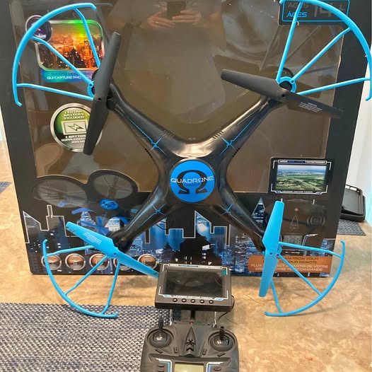 Blue quadcopter drone with four propeller guards and central camera module