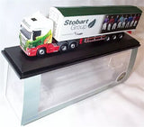Scania diecast truck model with white cab and green trailer, on display base