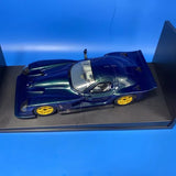 Two-tone blue diecast race car model with silver hood and yellow wheels