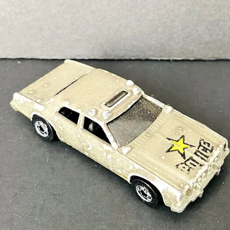 Light tan diecast police patrol car with yellow star decal