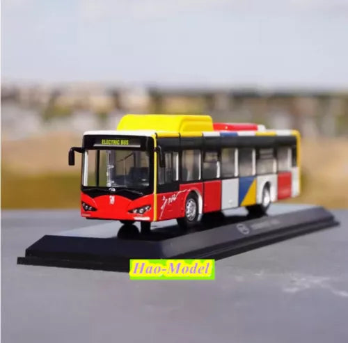 Red and black diecast bus model with yellow roof on display base