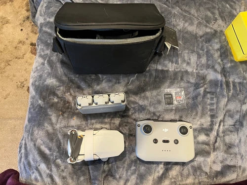 DJI Mini 2 drone with remote controller, battery pack, and black carrying case