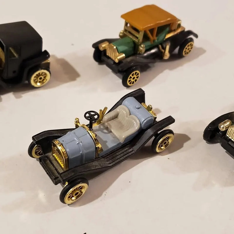 Diecast antique car model with light blue body, gold trim, open cabin and black wheels