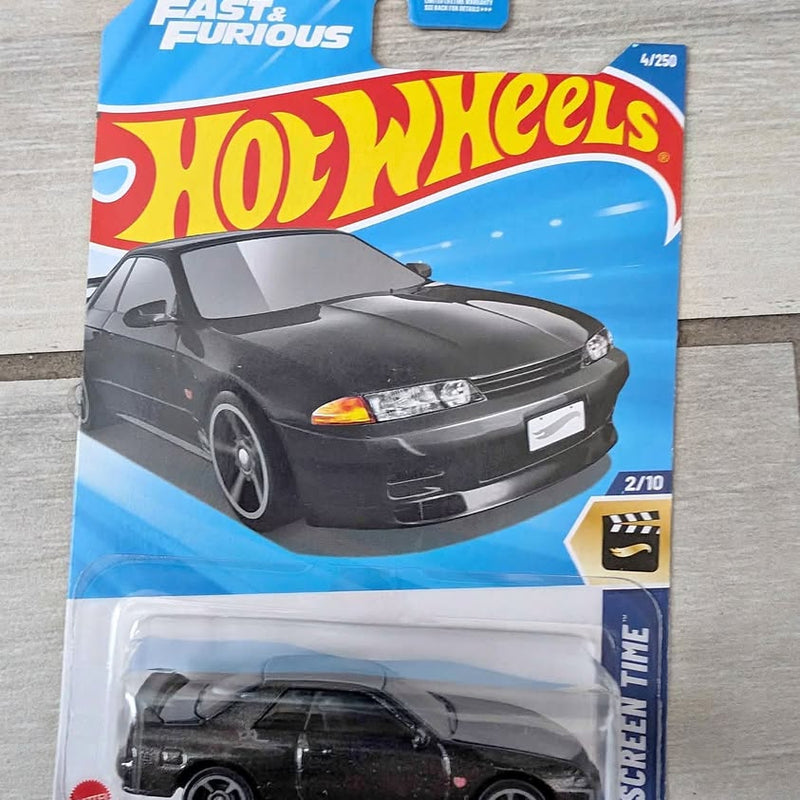 Hot Wheels diecast model car in blister pack, black sports coupe front view