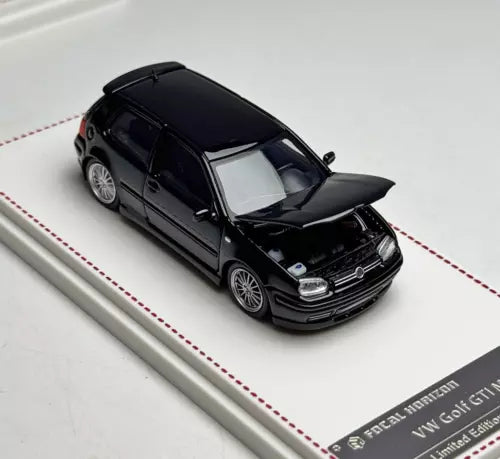 Black diecast coupe model car with open hood, front three-quarter view