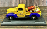 Yellow vintage diecast farm truck with purple front and farm equipment, 1:24 scale.