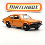 Orange metalflake diecast coupe car with black wheels and front grille, 1:64 scale