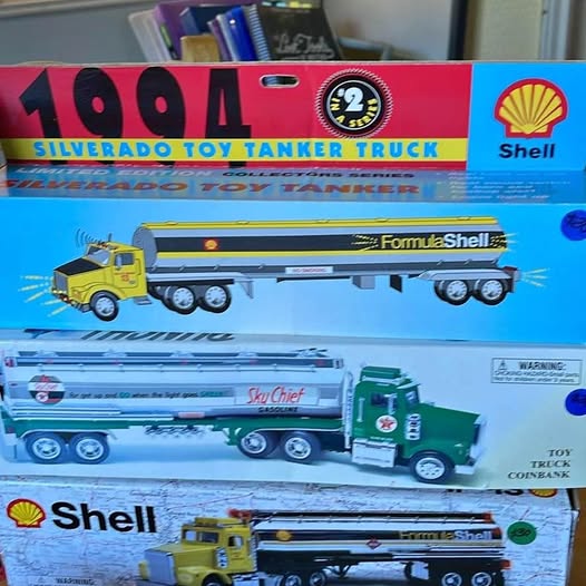 Diecast toy tanker truck box with Shell-themed trucks and yellow and blue vehicles