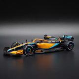 Orange and black diecast Formula racing car model, front three-quarter view.