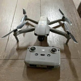 White quadcopter drone with four arms and propellers, viewed from above