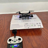 Black quadcopter drone with remote controller on packaging box