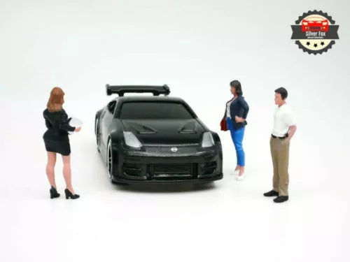 1:64 scale diecast car diorama with three sales figurines around a dark sedan