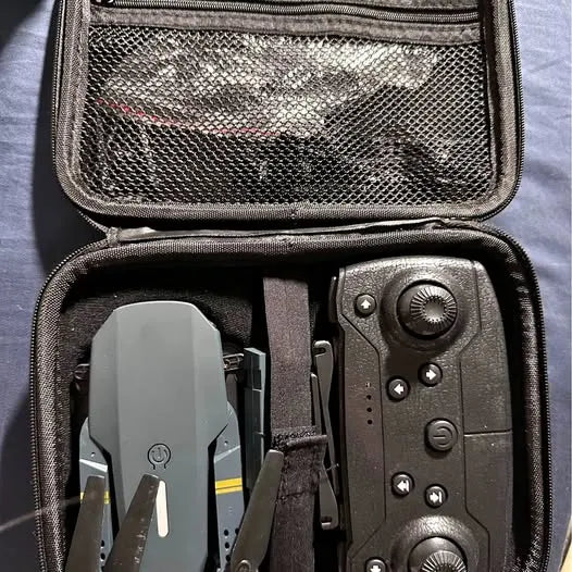 Open drone carrying case with remote controller and folded drone inside