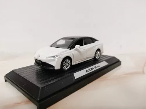 White diecast model car on display base, black windows and hood trim