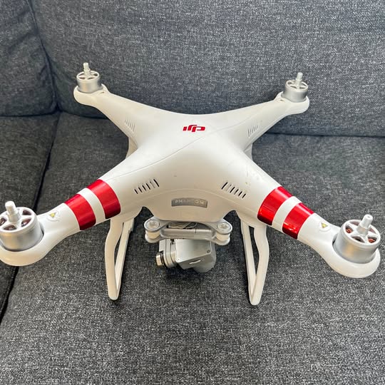 White quadcopter drone with red stripes and front camera module