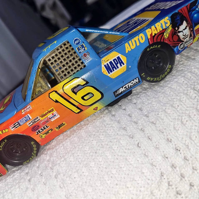 Blue NASCAR diecast truck with Superman graphic and large yellow number 16