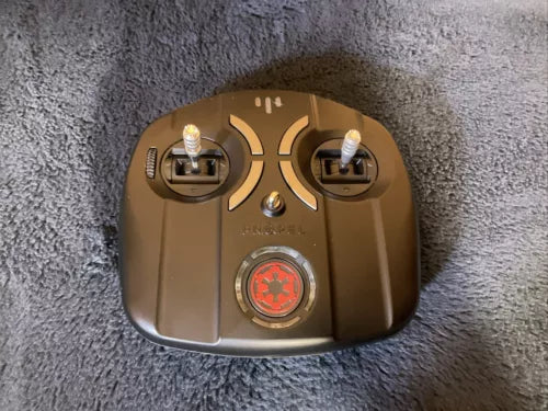Remote controller with two antennas and central red dial, gold-brown casing