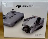 DJI Mini 4 Pro drone in retail box, with remote and camera module shown