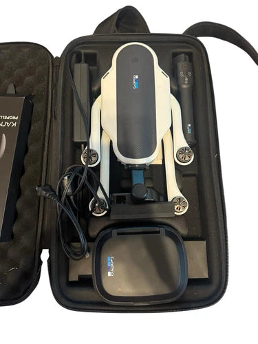 Folded drone in zippered carrying case with controller, cables, and battery dock