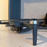 Compact dark blue drone with front camera and four propeller arms