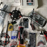 Drone kit with quadcopter frame, antennas, remote controller and accessories in boxes
