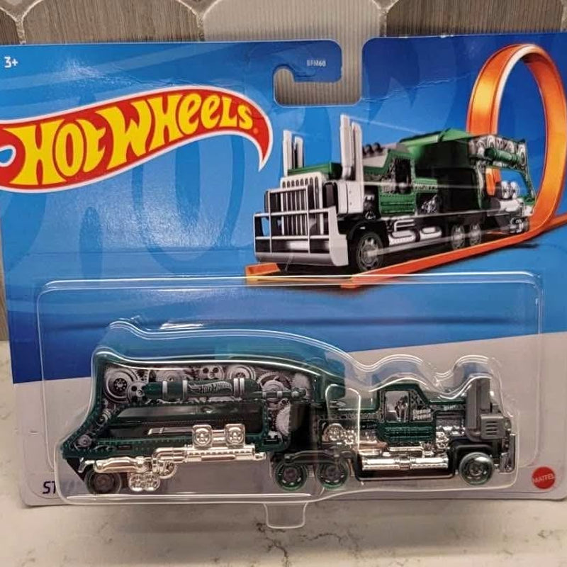 Hot Wheels diecast truck in blister packaging, dark gray with green accents