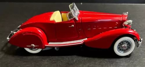 Red classic diecast speedster car with whitewall tires, front side view