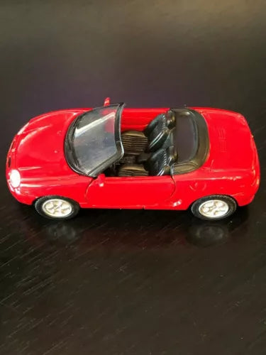 Red diecast convertible car with open door, interior visible