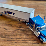 Blue diecast tractor trailer replica with Swift logo on silver trailer and front cab details