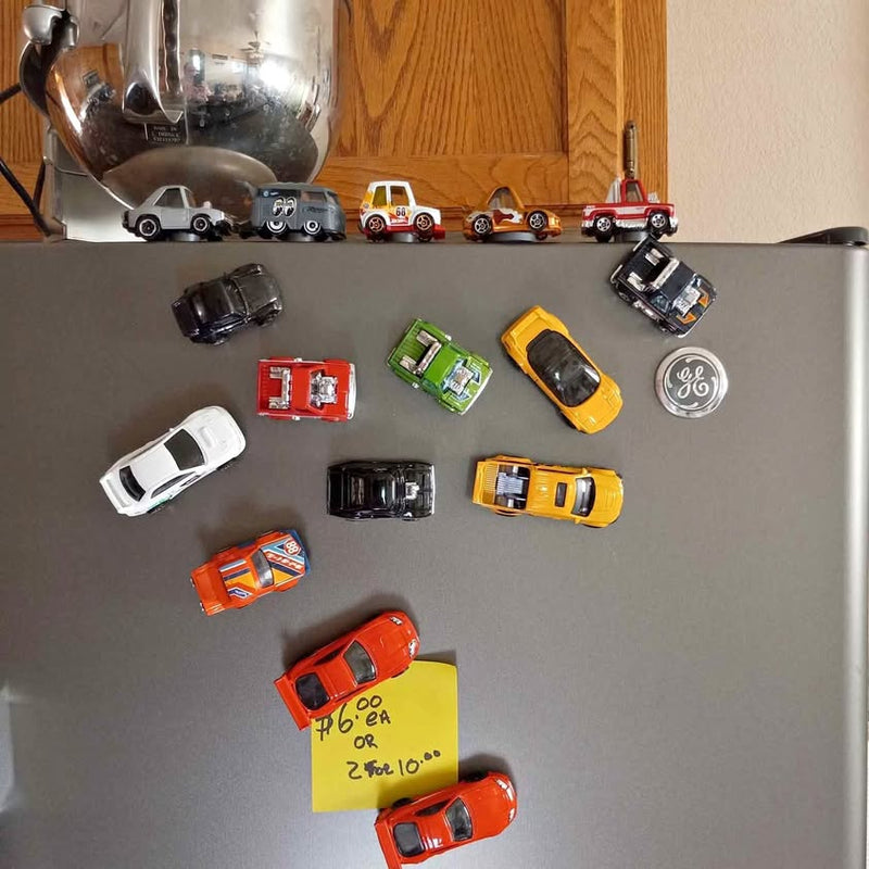 Collectable diecast car models assortment, various colors on a dark surface