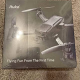 Gray drone with camera on retail box, with four propellers and folded body