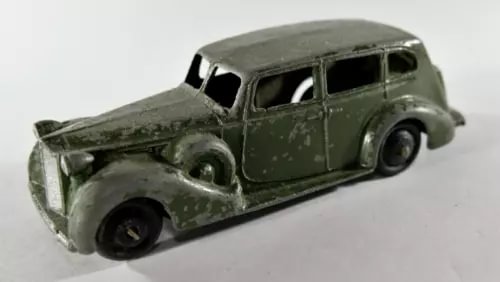 Green diecast toy car, classic four-door tourer body, front three-quarter view