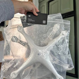 Drone accessory kit in clear plastic bag with white components