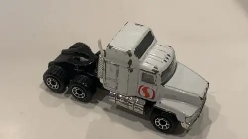 White toy diecast truck with black trailer parts, Mack CH500 style