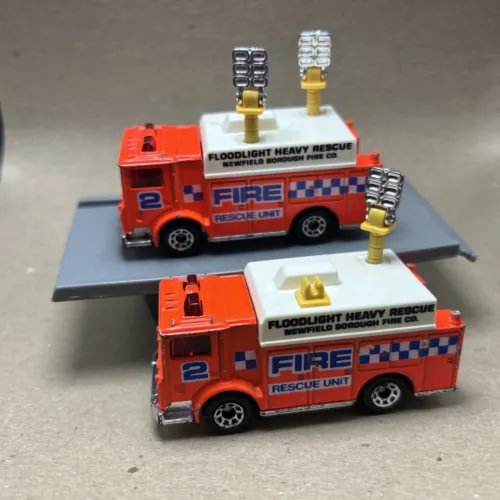 Orange diecast fire rescue truck with front and rear floodlight towers