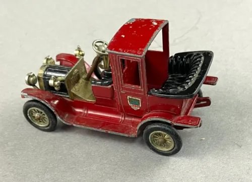 Red diecast vintage car model with gold grille, black interior, open top