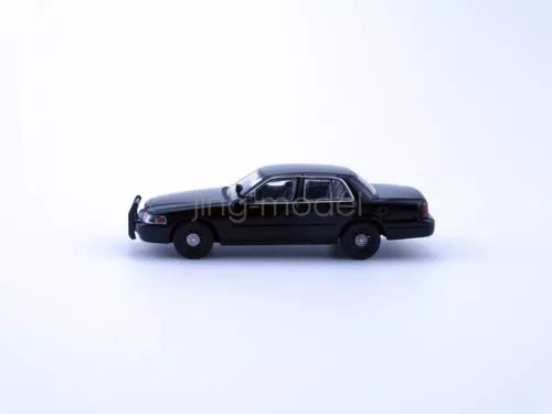 Black diecast police sedan model car, 1:64 scale, side view.